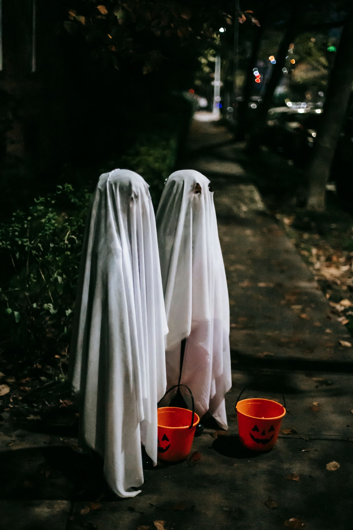 Kids in ghost costumes trick-or-treat