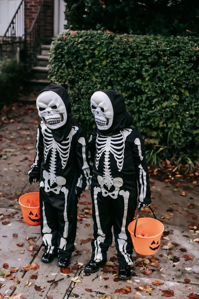 Kids in skeleton costumes with buckets